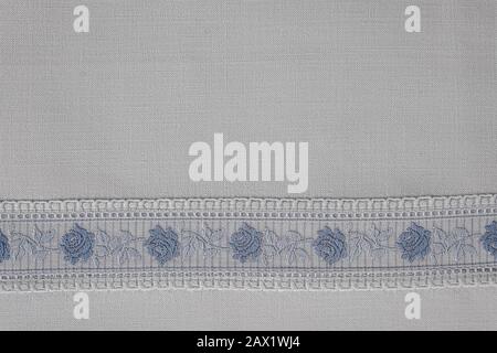 Embroidered border with roses in blue white on a white cotton table cloth Stock Photo