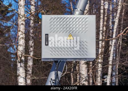 Metal box with electric equipment fixed on the street lantern. Stock Photo