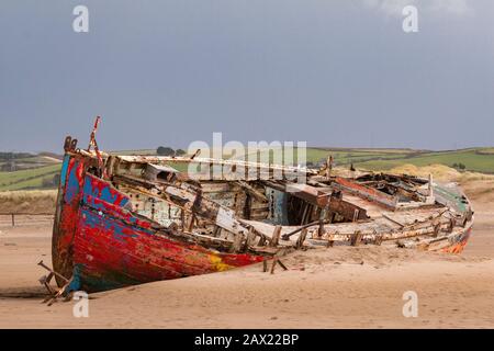 A colourful shipwreck rests on the beach at Crow Point in North  Devon, England. Stock Photo