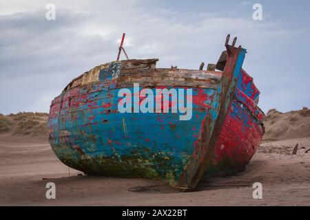 A colourful shipwreck rests on the beach at Crow Point in North  Devon, England. Stock Photo