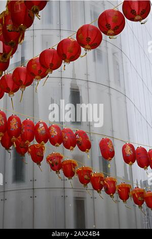 Red Chinese New Year lanterns set against white building in Chinatown, Soho, London Stock Photo