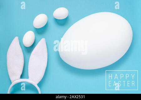 Easter concept. Rabbit ears and white eggs. On a blue background. Stock Photo