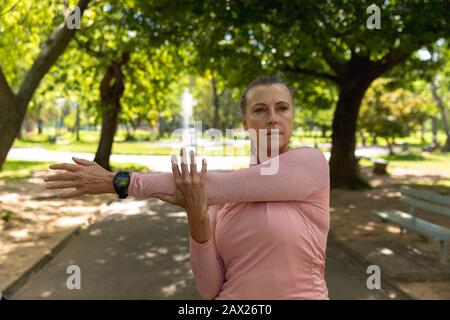 Female jogger stretching in the park Stock Photo