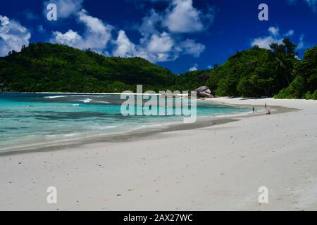 Tourists spending time on the beach - Baie Lazare beach, Mahe Island, Seychelles. Stock Photo