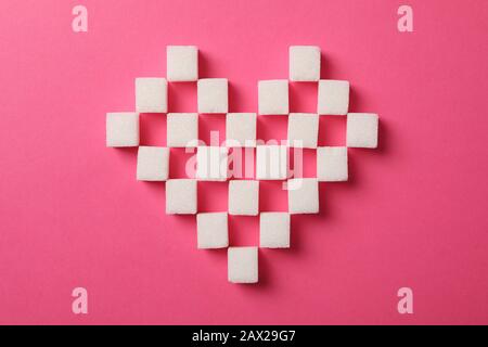 Heart made of sugar cubes on pink background, top view Stock Photo
