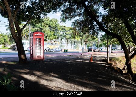 Londrina PR, Brazil - December 23, 2019: Red phone booth next to the Higienopolis avenue and the Igapo lake. Stock Photo