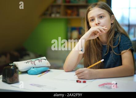 young girl focused on drawing at home Stock Photo