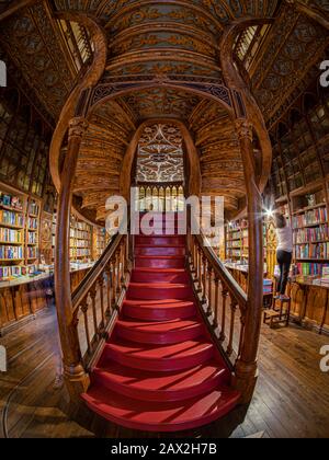 Interiors of Lello Bookstore (Portuguese: Livraria Lello) showing its famous wooden staircase in the Historic Center of Porto, Portugal. Stock Photo