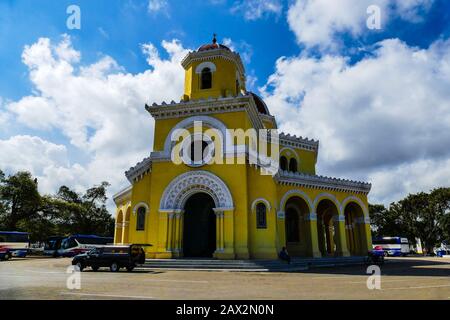The Columbus Cemetery is a necropolis located in Cuba in the El Vedado district of Havana and founded in 1876. Hearse in front of a yellow church Stock Photo