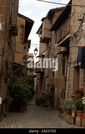 Narrow alleyway, tall old dark houses in medieval Sutri Italy Stock Photo