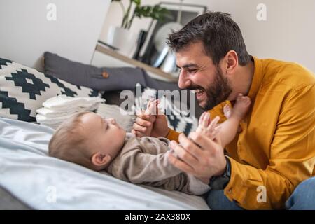 Father and baby.Young dad is changing baby diaper.Happiness and harmony in family life.Family, love,happiness and people concept. Stock Photo