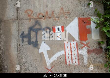 Which way to go instructions painted on wall in Italy guiding pilgrims and hikes the best route to take on the Via Francigena route. Go under the road Stock Photo