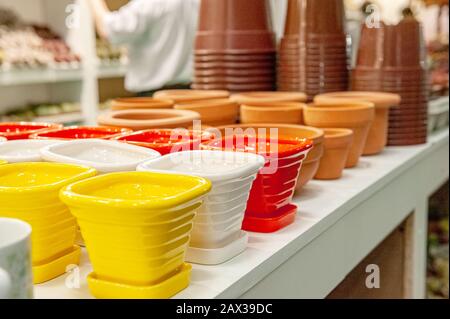Glazed colored porcelain flower pots for sale in a garden store. Selective focus. Stock Photo