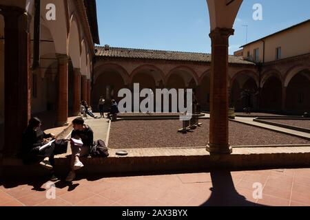 Students studying at the courtyard in the Richard Goodwin faculty University of Siena Tuscany Italy Stock Photo