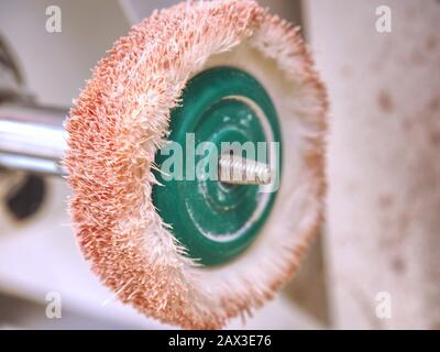 Dusty rotating metal brush. Power drill head with rotating brass brushes Stock Photo