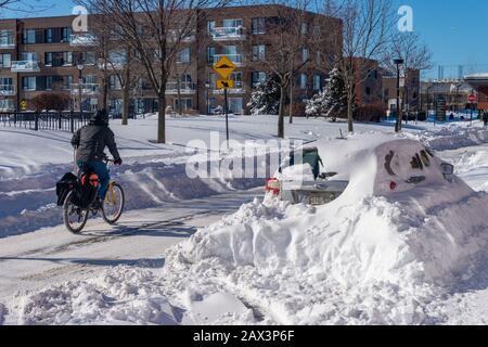 Montreal, CA - 8 February 2020: Man riding a bike in winter Stock Photo