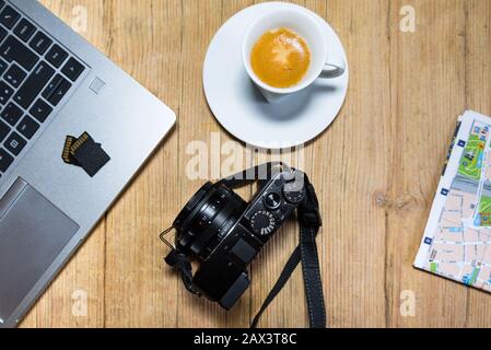 Travel planning on wooden desk table with camera, laptop, memory cards and city map. View from top. Stock Photo