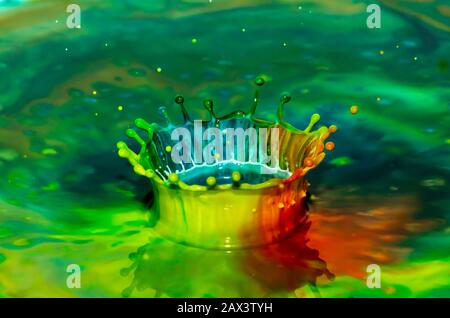Bursts of multi-colored bright colors of paint in the form of crowns and colorful splashes. Stock Photo