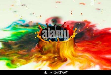 Bursts of multi-colored bright colors of paint in the form of crowns and colorful splashes. Stock Photo