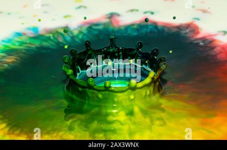 Bursts of multi-colored bright colors of paint in the form of crowns and colorful splashes. Stock Photo