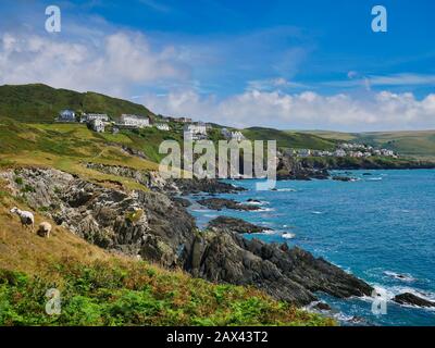 The seaside resort town of Woolacombe on the rugged north Devon coast. The foreground shows the steeply inclined slate strata of the Morte Slates Form Stock Photo