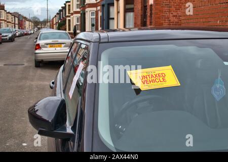 A notice is displayed on an untaxed vehicle advising that a report has been passed to the DVLA for enforcement action Stock Photo