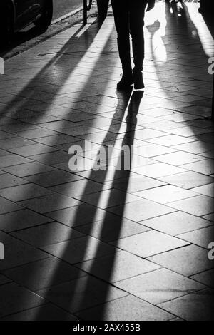 Long human shadows projected on the pavement at sunset Stock Photo