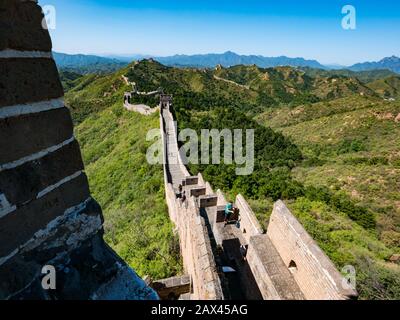 View from Xiaojinshan Tower wiht tourists walking on Jinshanling Great Wall of China in sunshine, Hebei Province, China, Asia Stock Photo