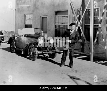 1930 ca , LOS ANGELES , USA  : The american silent movie actor and director BUSTER KEATON ( 1895 - 1966 ) in a pubblicity still - SILENT MOVIE - CINEMA MUTO  - portrait - ritratto -  regista cinematografico - attore  - comico   - COMICO -   ANNI TRENTA - 30's - '30 - basco - hat - cappello - tie - cravatta - doppiopetto - pochette - fazzoletto nel taschino - macchina decapottabile - car - traino   ----  ARCHIVIO GBB Stock Photo