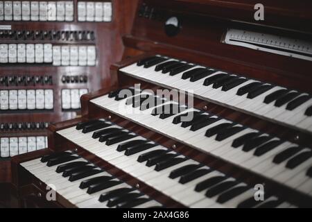 Keys and buttons on a big old brown church organ Stock Photo