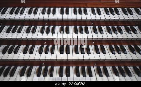 Many keys on a big old brown church organ Stock Photo