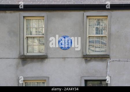 A circular blue history plaque between two wooden windows on the wall of a building in Letterkenny, County Donegal, commemorating James Duffy VC. Stock Photo