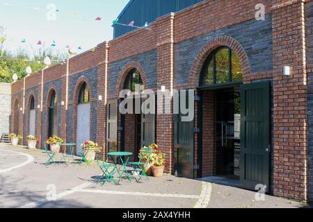 Courtyard style exterior with tables outside Buffers the café/restaurant at Oakfield Park Raphoe on a sunny autumn afternoon in County Donegal. Stock Photo