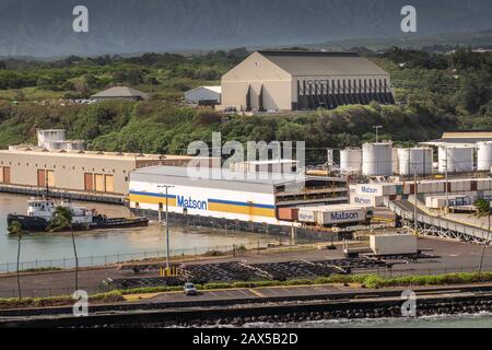 Nawiliwili, Kauai, Hawaii, USA. - January 17, 2020: Matson covered shipping container barge with puilling tugboat. Guardian Self Storage werehouse on Stock Photo