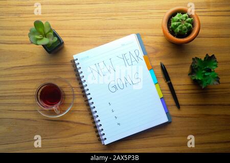 new year goals written on notepad on table  Stock Photo