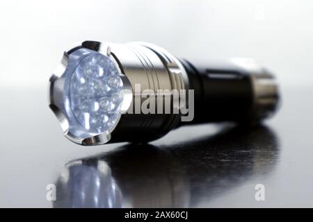 Close up photo of small led flashlight on a wooden table Stock Photo