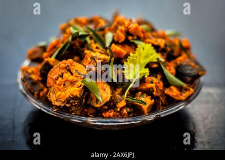 Famous Indian & Gujarati snack dish in a glass plate on wooden surface i.e. Patra or paatra consisting of mainly Colocasia esculenta or arbi ke pan or Stock Photo