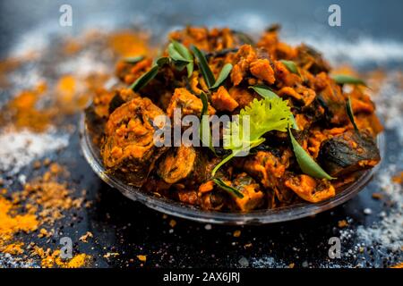 Famous Indian & Gujarati snack dish in a glass plate on wooden surface i.e. Patra or paatra consisting of mainly Colocasia esculenta or arbi ke pan or Stock Photo