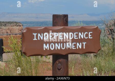 FRUITA, COLORADO - JUNE 23, 2016: Independence Monument Sign Along Rim Rock Drive in Colorado National Monument With Grand Valley & Book Cliffs Beyond Stock Photo