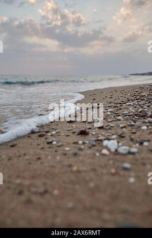 Vertical shot of pebbles on a beach under the clouded sky Stock Photo