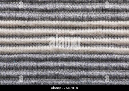 Grey colored striped coarse fabric texture closeup as background. volumetric striped pattern. Stock Photo