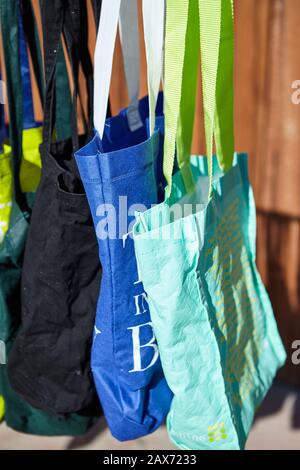 Low angle shot of colorful eco-friendly reusable cloth bags hanging on a pole - no plastic concept Stock Photo