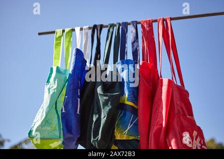 Low angle shot of colorful eco-friendly reusable cloth bags hanging on a pole - no plastic concept Stock Photo