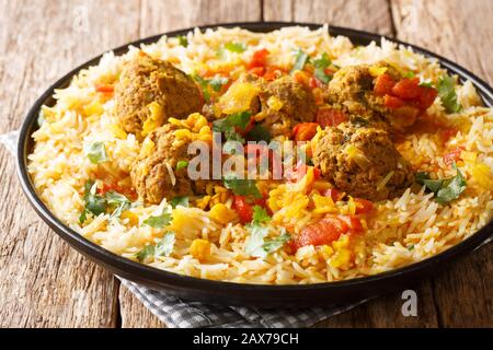 Kofta Chalao Stewed meat balls in spicy sauce with yellow peas served with basmati rice close-up in a plate on the table. horizontal Stock Photo