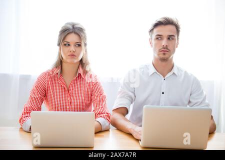 Portrait of two serious concentrated man and woman with laptops Stock Photo