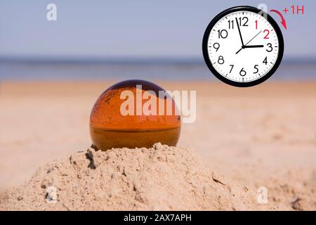 Daylight Saving Time (DST). Blue sky with white clouds and clock. Turn time forward (+1h). Stock Photo