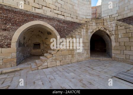 Exterior of ancient brick building with shabby stone stairway and two crumbling arched alcoves on street Stock Photo