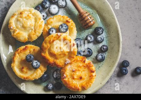 Cottage cheese pancakes with blueberries, gray background. Stock Photo