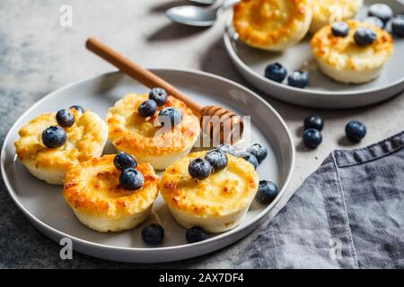 Cottage cheese pancakes with blueberries, gray background. Stock Photo