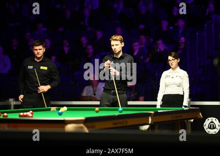 Simon Lichtenberg of Germany, middle, considers a shot to Ryan Day of Wales, left, at the first round of 2020 Welsh Open in Cardiff, the United Kingdom, 10 February 2020. Simon Lichtenberg of Germany defeated Ryan Day of Wales with 4-1. Stock Photo